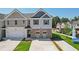 Two-story townhome with gray and beige siding, brick accents, and a two-car garage at 318 Crimson Dr, Union City, GA 30291