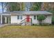 Charming ranch home with red front door and well-maintained lawn at 1883 Meadow Ln, Decatur, GA 30032