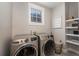 Well-equipped laundry room with modern washer and dryer, and ample shelving at 238 Fowler St, Woodstock, GA 30189