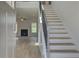 Bright entryway with gray door, hardwood floors, and a staircase with an iron railing at 173 Haverling Pass, Hampton, GA 30228