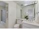 Bright bathroom with white vanity, toilet, shower, and orchid plant at 1726 Houghton S Ct, Dunwoody, GA 30338