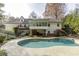 Back of house showcasing pool, deck, hot tub, and lush landscaping at 1726 Houghton S Ct, Dunwoody, GA 30338