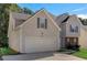 Beige two-story house with a two-car garage and landscaping at 3053 Highland Park Ln, Lithonia, GA 30038