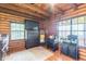 Cozy bedroom with log walls, a dresser, and plenty of natural light at 58 Wesley Chapel Ln, Villa Rica, GA 30180