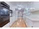 Long kitchen with white cabinets, hardwood floors and appliances at 176 Teresa Ln, Loganville, GA 30052