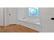 Relaxing bathroom with a large garden tub and wood-look flooring at 157 Reynolds Rd, Bowdon, GA 30108