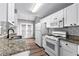 Kitchen with white cabinets, granite countertops, white appliances, and tile backsplash at 152 Lost Lake Trl, Villa Rica, GA 30180