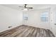 Well-lit bedroom, featuring wood-look floors and two windows at 703 Pine Tree Trl, Atlanta, GA 30349