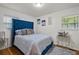 Bedroom with blue upholstered bed, geometric bedding, and gold accents at 3230 Santa Fe Sw Trl, Marietta, GA 30060