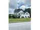 Two-story white house with black shutters, a gray roof and landscaping at 540 Langley Creek Dr, Loganville, GA 30052