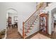 Two-story entryway with staircase, wood floors, and display cabinet at 512 Star Flower Ln, Sugar Hill, GA 30518