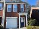 Brick front exterior of townhome with attached garage and landscaping at 3230 Mill Springs Cir, Buford, GA 30519