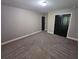 Large bedroom with grey carpet and double dark doors at 1256 St James Pl, Loganville, GA 30052