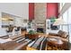 Open-concept living room with a stone fireplace, built-in bookshelves, and view of the kitchen at 1440 Tamarack Way, Alpharetta, GA 30005