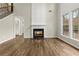 Living room with fireplace, wood floors, and large windows offering natural light at 608 Chickory Ct, Woodstock, GA 30188