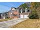 Brick two-story house with a three-car garage and a landscaped yard at 642 Towering Pine Trl, Lawrenceville, GA 30045