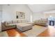 Living area with sectional sofa, hardwood floors, and view towards the foyer at 310 Butler Bridge Cir, Covington, GA 30016