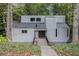 Gray house with wood deck and walkway, nestled among lush green trees at 1473 Ragley Hall Ne Rd, Brookhaven, GA 30319