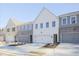 Modern townhome community with gray and white exteriors, two-car garages, and landscaping at 907 Agate Ln, Lawrenceville, GA 30043