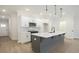 Modern kitchen with white cabinets, gray island, quartz countertops, and stainless steel appliances at 907 Agate Ln, Lawrenceville, GA 30043