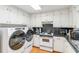 Kitchen with white cabinets, black countertops, and laundry appliances at 348 Pine Forest Dr, Lawrenceville, GA 30046