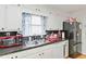 Kitchen features white cabinets, double sink, and black countertops at 348 Pine Forest Dr, Lawrenceville, GA 30046