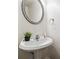 Small powder room with pedestal sink and vanity mirror at 3547 Valley Bluff Ln, Snellville, GA 30039