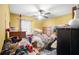 Yellow bedroom with ceiling fan, bed, and dresser. Needs organizing at 714 Lanford Springs Sw Dr, Lilburn, GA 30047