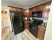 Kitchen with dark wood cabinets and black appliances at 350 Chestnut Dr, Covington, GA 30016