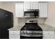 Stainless steel gas range and microwave in a bright kitchen at 2213 Asquith Sw Ave, Marietta, GA 30008