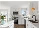 Modern white kitchen with stainless appliances, quartz countertops, and wood floors at 1975 Lakewood Rd, Cumming, GA 30041