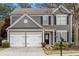 Two-story gray house with white trim, two-car garage, and landscaping at 124 Wallnut Hall Cir, Woodstock, GA 30189