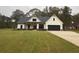 Modern farmhouse with white siding, black roof and accents, large windows, and a green lawn at 236 Harmony Ridge Dr, Temple, GA 30179