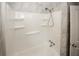 White shower and tub combination in a bathroom with marble tile walls at 5760 Lakeview Dr, Powder Springs, GA 30127