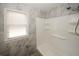 Shower/tub combo in a bathroom with marble-look tile and built-in shelving at 5760 Lakeview Dr, Powder Springs, GA 30127