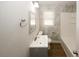 Full bathroom with marble-look tiled walls, vanity sink, toilet, and shower/tub combo at 5760 Lakeview Dr, Powder Springs, GA 30127