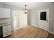 Dining area with wood-look flooring, white door, and decorative light fixture at 5760 Lakeview Dr, Powder Springs, GA 30127