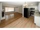 Kitchen and living area with wood-look flooring, white cabinets, and stainless steel appliances at 5760 Lakeview Dr, Powder Springs, GA 30127