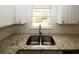 Modern kitchen featuring granite countertops, white subway tile backsplash, and stainless steel sink at 5760 Lakeview Dr, Powder Springs, GA 30127