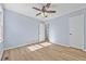 Light blue bedroom with wood-look floors and access to hallway at 111 Charles Pl, Cumming, GA 30040