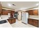 Kitchen with wood cabinets, white appliances, and tile floors at 1845 Branch Valley Dr, Roswell, GA 30076