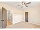 Well-lit bedroom with carpet, ceiling fan, and access to hallway at 106 Red Oak Ln, Carrollton, GA 30116