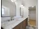 Main bathroom featuring dual arched mirrors, marble countertop, and checkered tile floor at 4147 Mcever Park Dr, Acworth, GA 30101