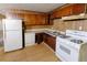 Kitchen with wood cabinets, white appliances and wood flooring at 6494 Bimini Dr, Forest Park, GA 30297