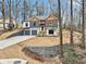 Two-story home with gray siding, wood accents, and a three-car garage, hillside lot at 447 Teague Nw Dr, Kennesaw, GA 30152