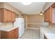 Kitchen with oak cabinets, white appliances, and tile floor at 2820 Quarters Ln, Powder Springs, GA 30127