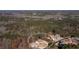 An aerial view showcases the home's location within a wooded, residential neighborhood near a lake at 1560 Tapestry Rdg, Lawrenceville, GA 30045