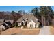 Aerial view of a two-story house with a landscaped yard and driveway in a wooded area at 1560 Tapestry Rdg, Lawrenceville, GA 30045