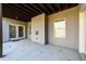 Covered concrete patio on the back of the house with a wooded view at 1560 Tapestry Rdg, Lawrenceville, GA 30045