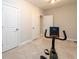 Carpeted basement room with exercise bike and multiple doors at 1560 Tapestry Rdg, Lawrenceville, GA 30045